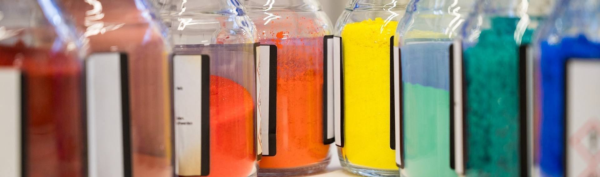 mehrere kleine Flaschen im Chemielabor mit farbigem Pulver