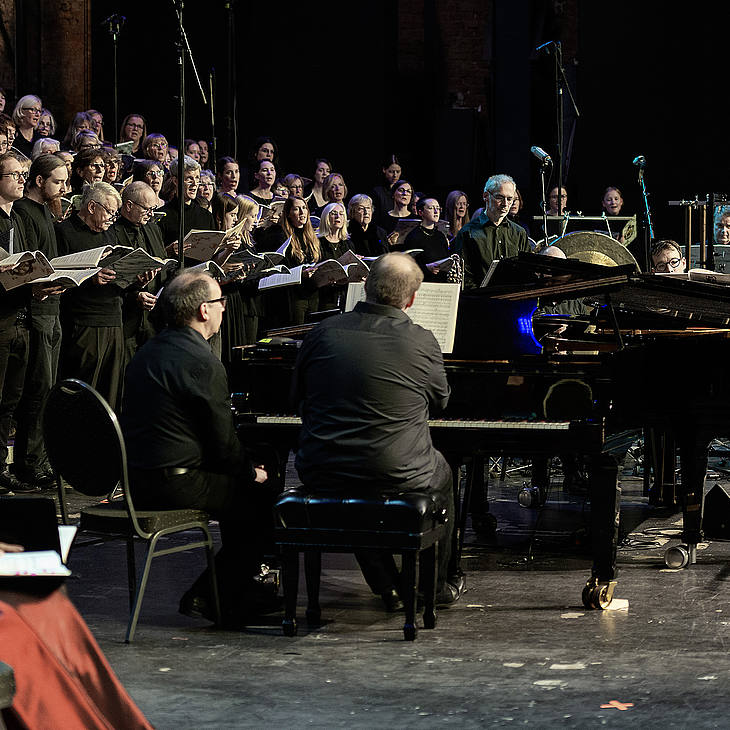 Der Chor singt, im Vordergrund die zwei Pianisten Tobias Markutzik und Wolfgang Heilmann