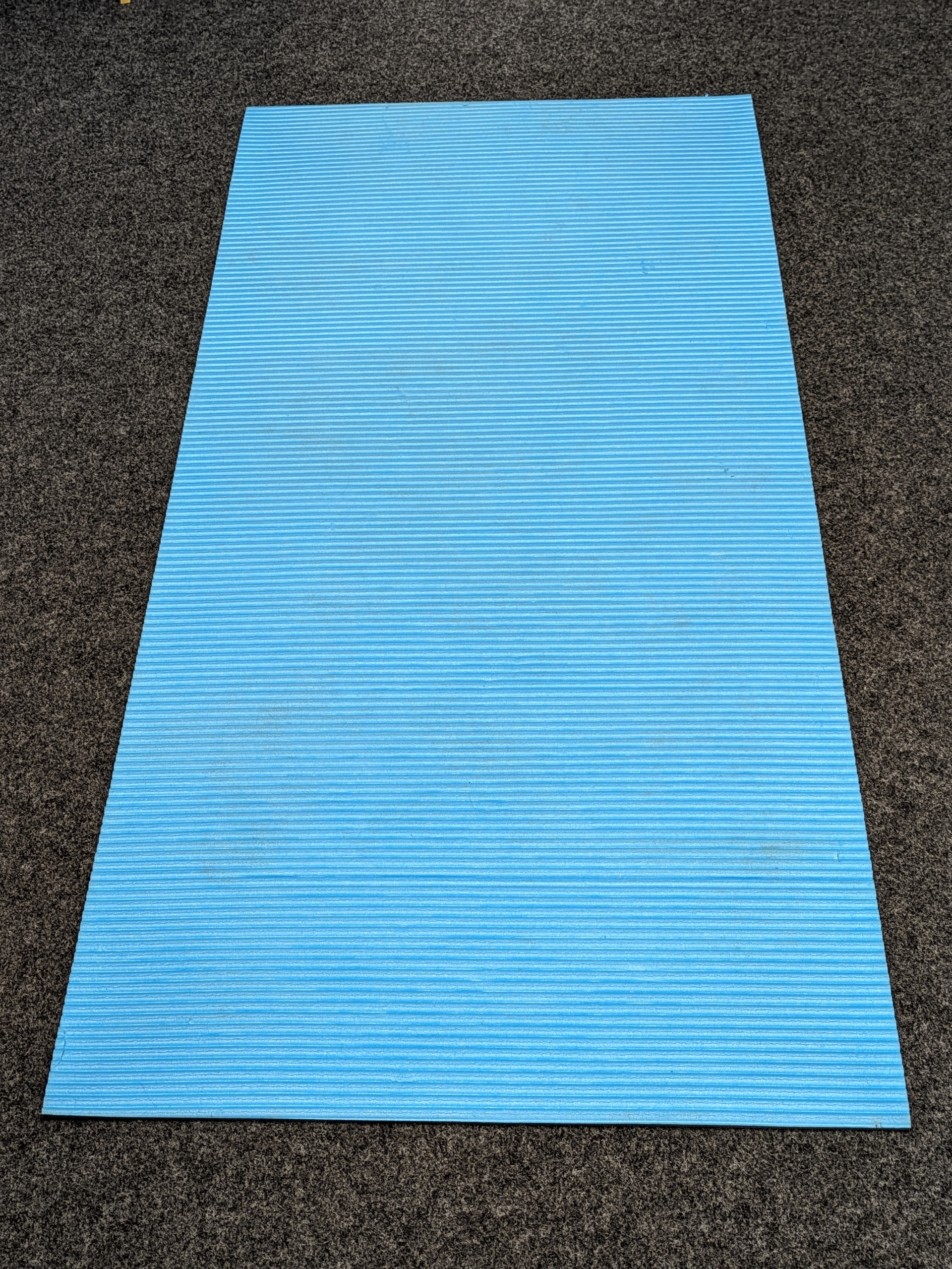 Foto von blauer Yogamatte, die auf dem Boden ausgebreitet ist