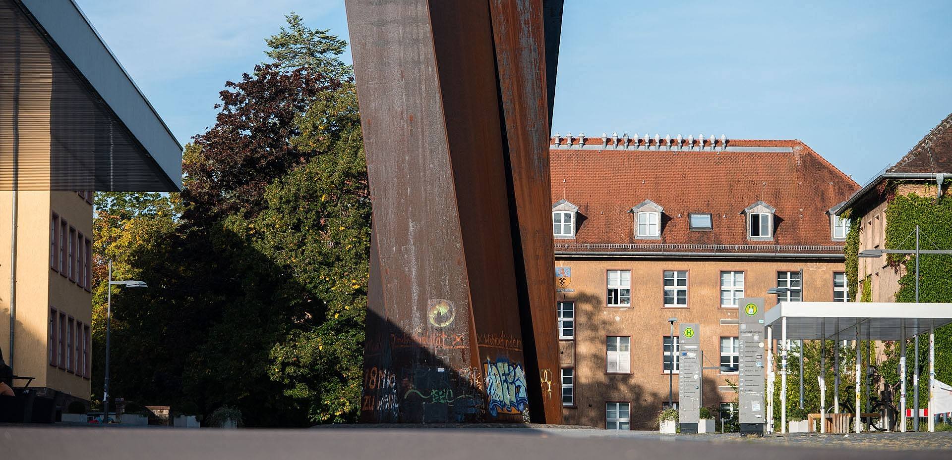 Campusansicht: Die Stahlskulptur Torque von Richard Serra umgeben von Universitätsgebäuden