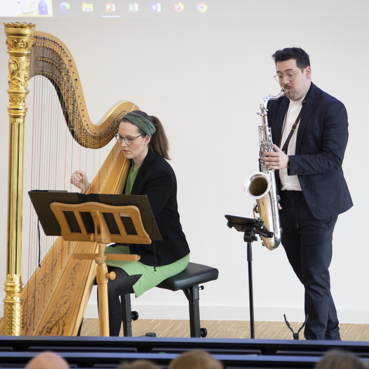 Zwei Musiker an Harfe und Saxophone beim Netzwerksymposum