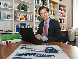 Das Bild zeigt Professor Georg Borges an seinem Schreibtisch.