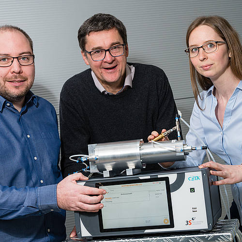 Tobias Baur, Professor Andreas Schütze und Caroline Schultealbert sind mit einer technischen Apparatur und Messgeräten zu sehen.