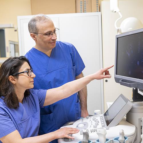 Zwei Ärzte schauen eine Ultraschallbild am Bildschirm an.