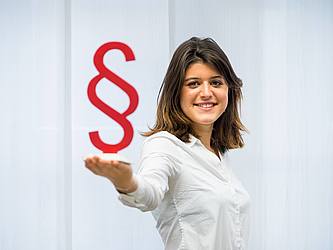 Eine Studentin hält ein Paragraphenzeichen - Symbolbild Rechtswissenschaft an der Universität des Saarlandes