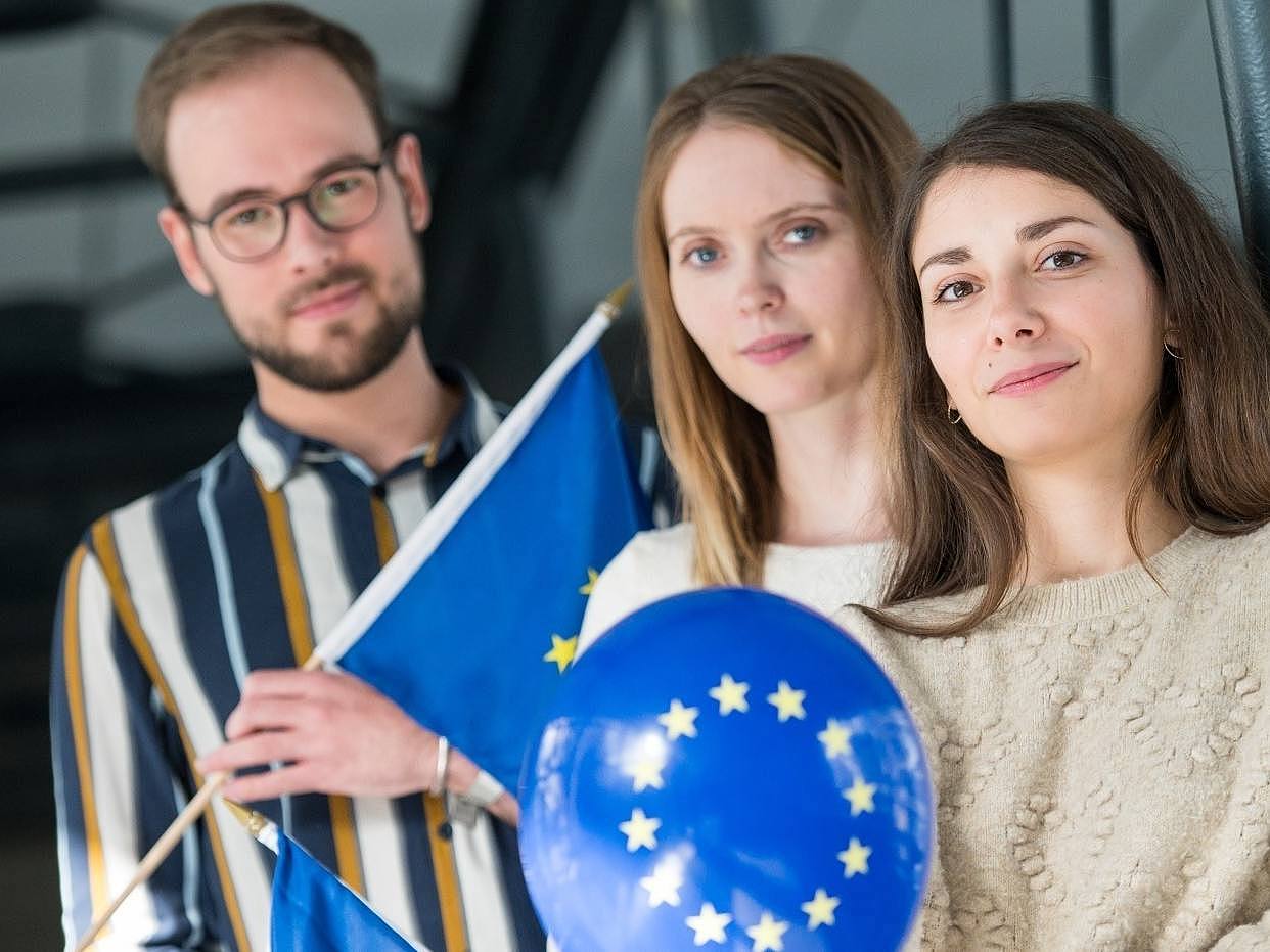 Studierende mit Europaflagge und Luftballon