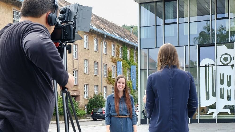 Dreharbeiten für ein Video: Kameramann filmt eine Frau vor dem Campus Centerdem Campus Saarbrücken