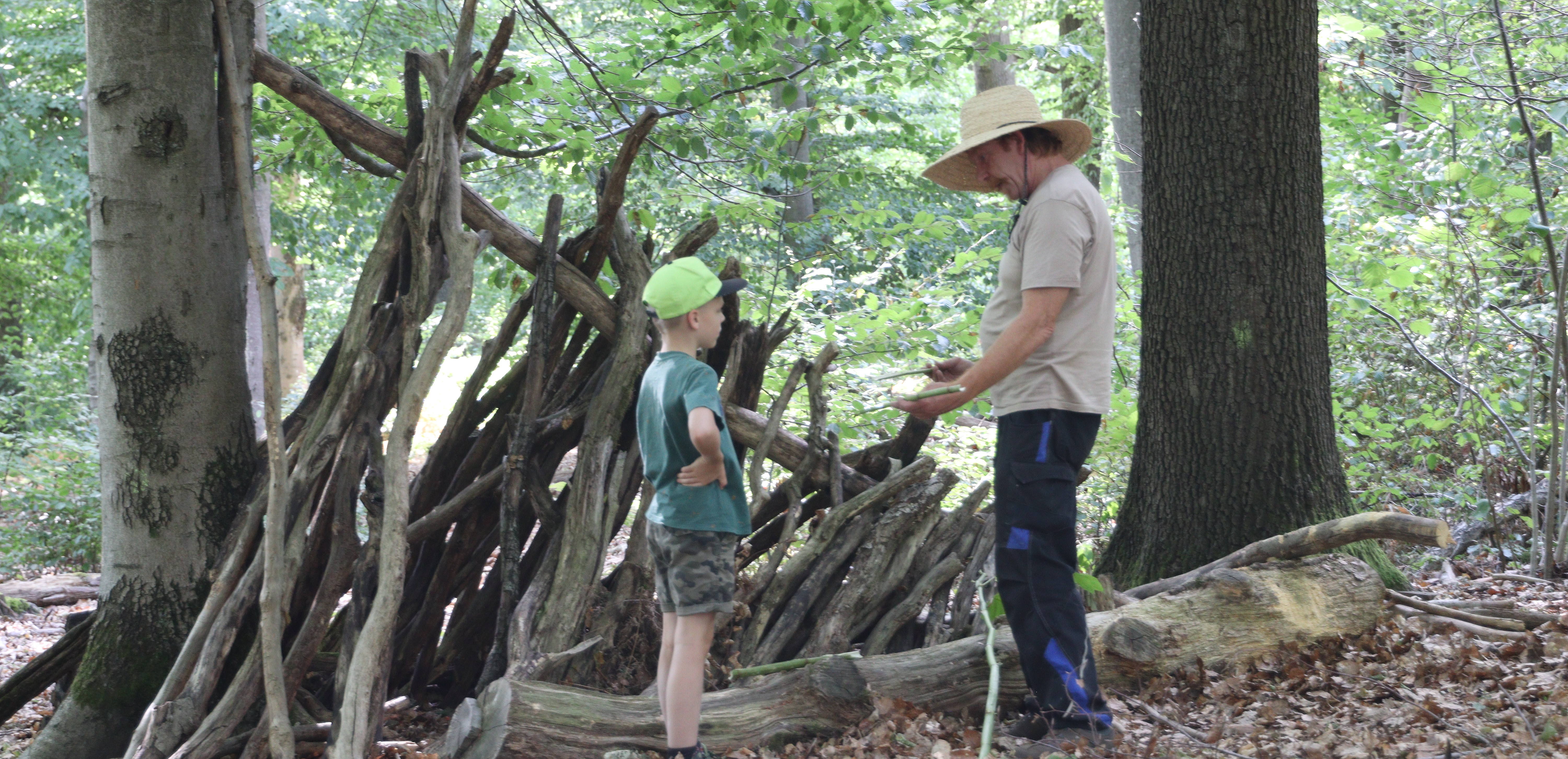 Guido und ein Kind am Bauen im Wald