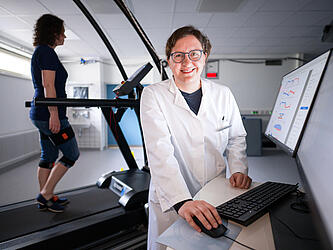 Prof. Dr. med. Bergita Ganse Bergita Ganse bei einer Studie im Labor. Zu sehen ist im Hintergrund eine Probandin auf dem Laufband.
