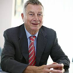 Porträtfoto: Werner Schmidt am Schreibtisch sitzend