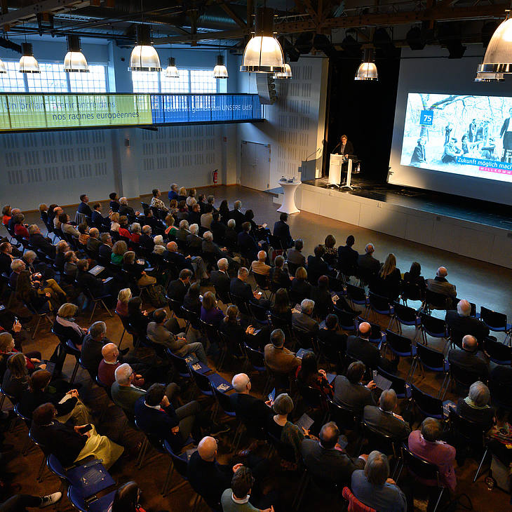 Blick von der Galerie aus auf das Publikum in der Aula der Universität des Saarlandes