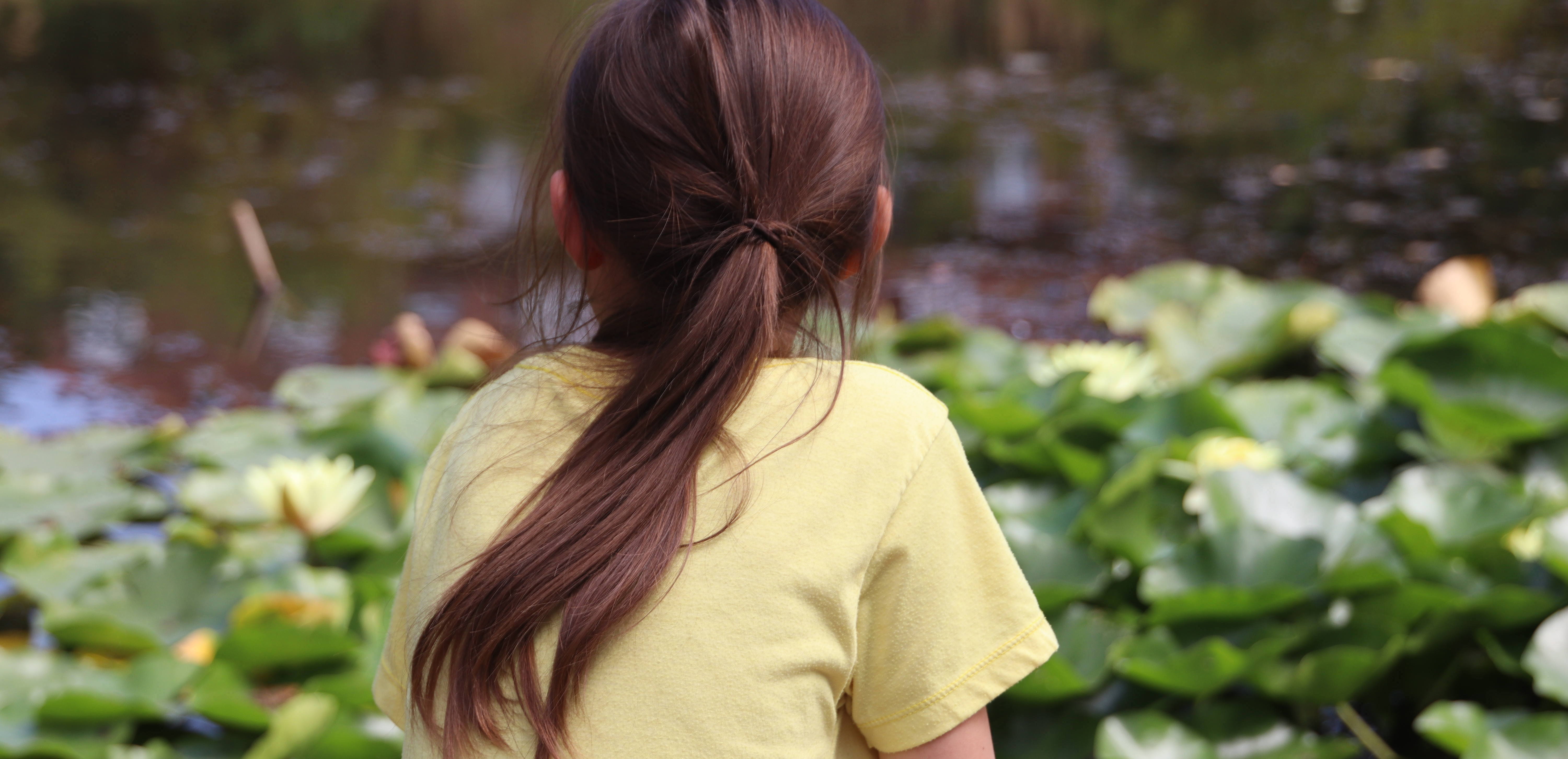 Impressionen FUNKT 2022: Kind in gelbem T-Shirt schaut sitzend auf einen Seerosenteich