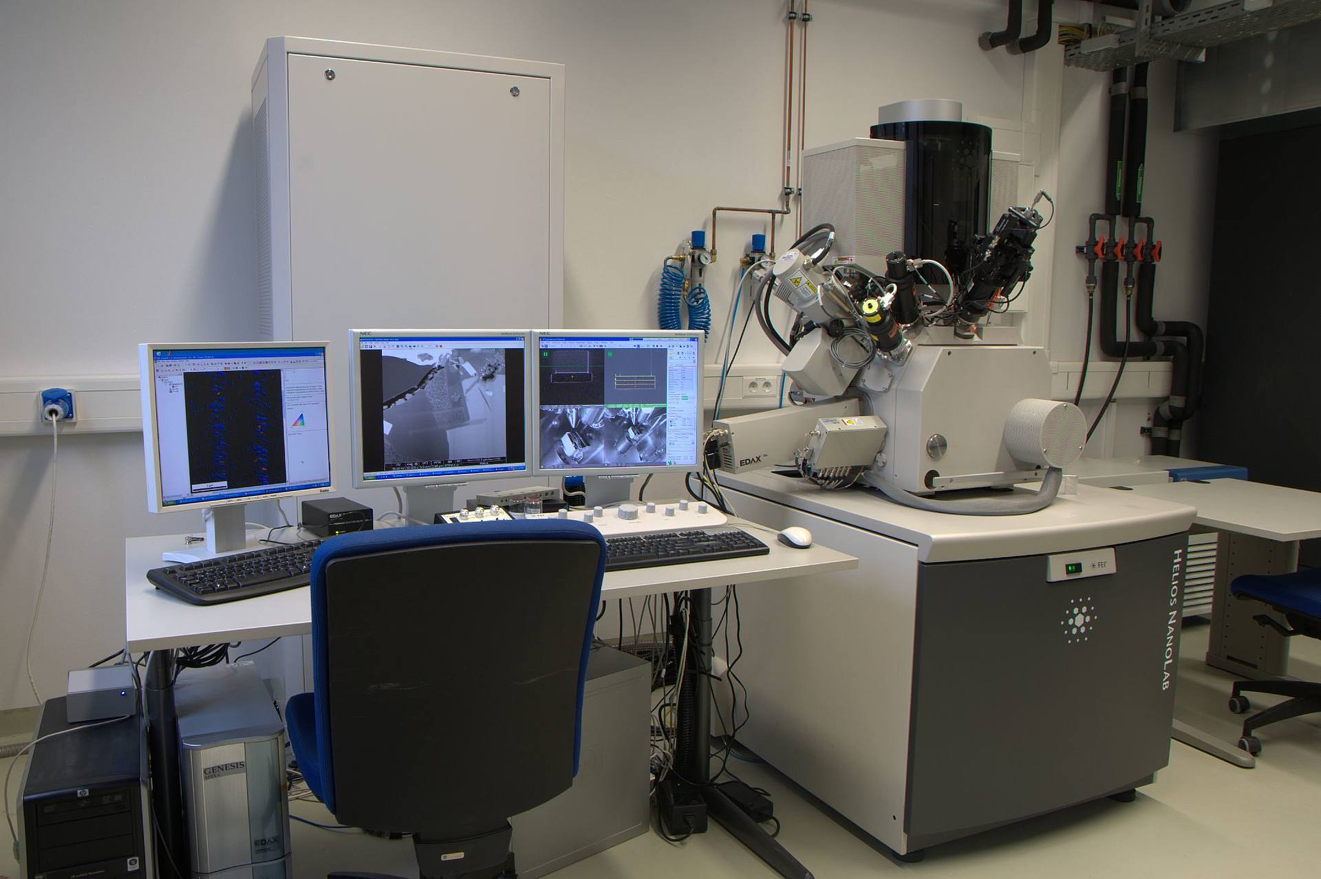 Laboraufnahme zeigt ein Focused Ion Beam Mikroskop und mehrere Bildschirme, die zur Steuerung verwendet werden.