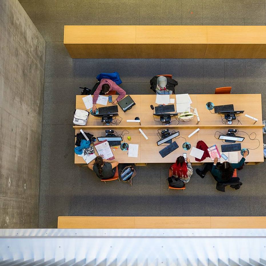 Tisch mit arbeitenden Studierenden in der Bibliothek 