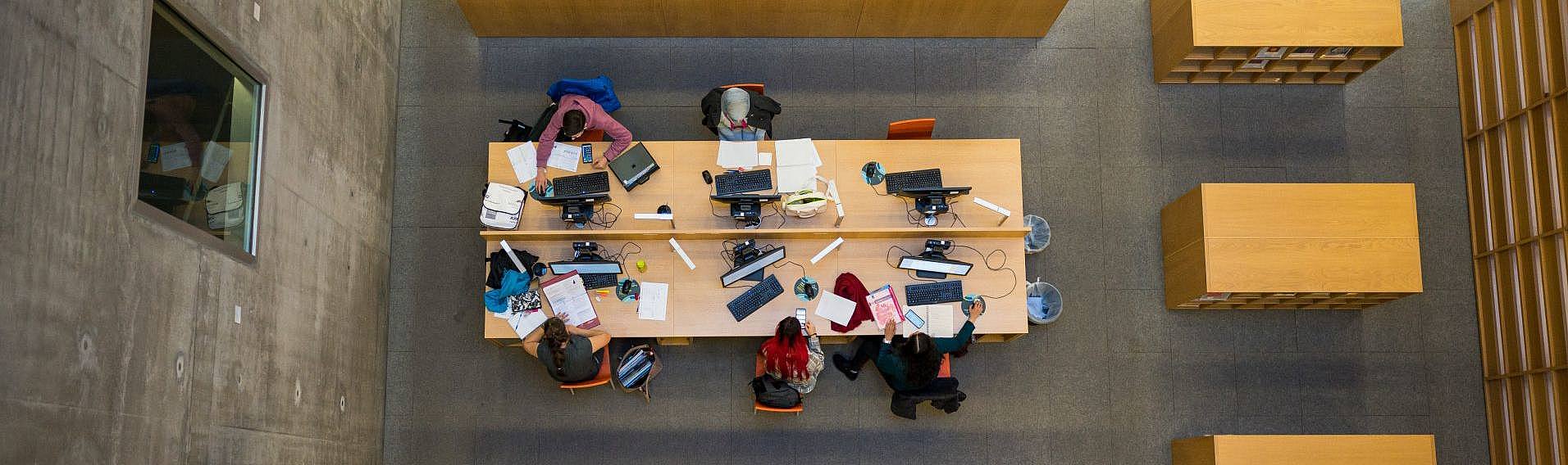 Tisch mit arbeitenden Studierenden in der Bibliothek 