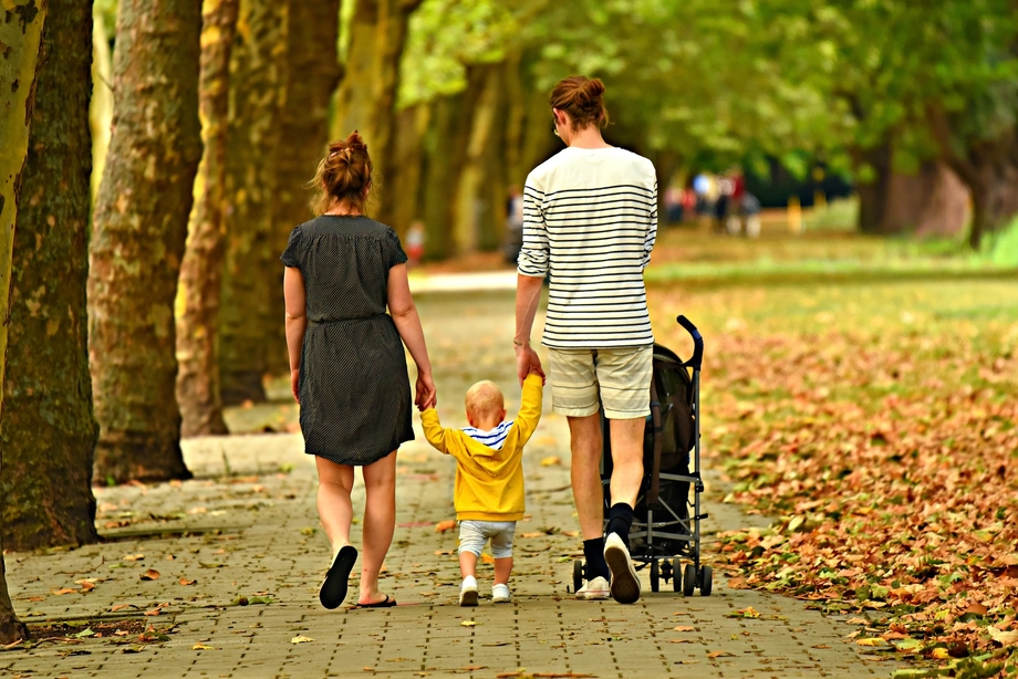Eine Familie mit Kind läuft eine Straße entlang