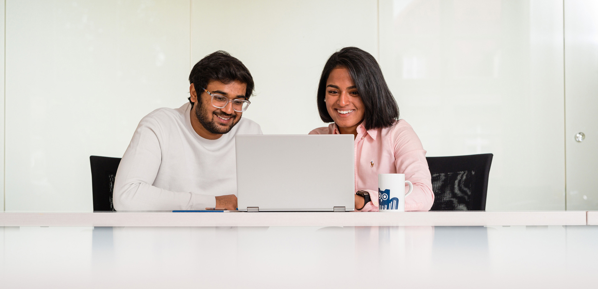 Junger Mann und junge Frau vor einem Laptop