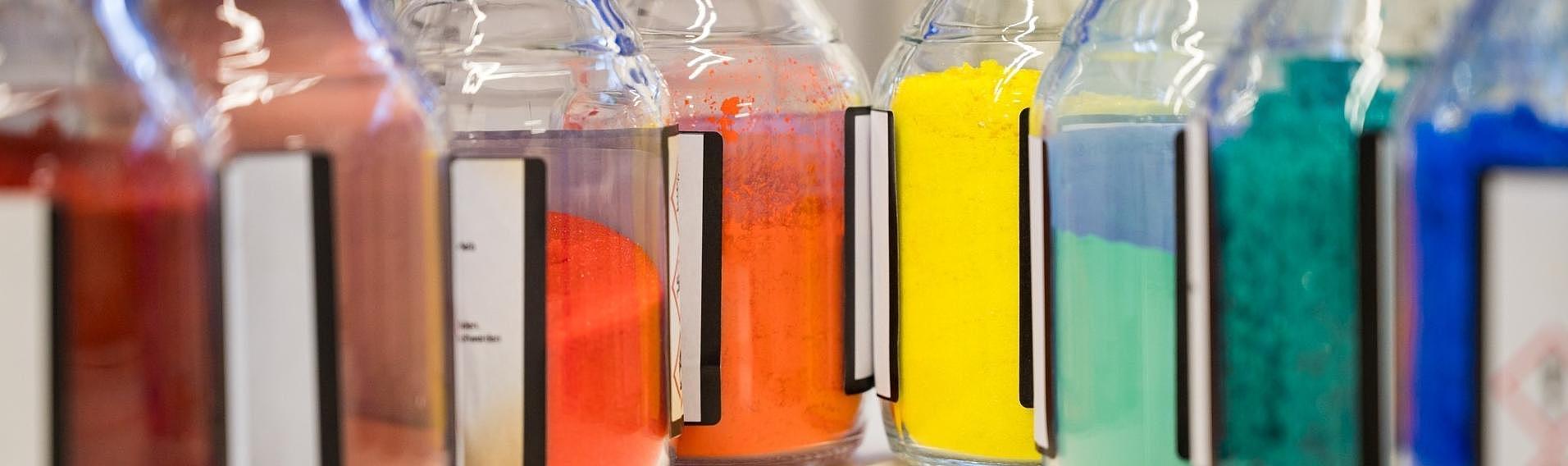 mehrere kleine Flaschen im Chemielabor mit farbigem Pulver