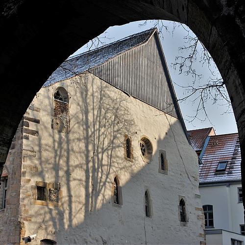 Blick durch einen Torbogen auf die Giebelwand der Alten Synagoge.