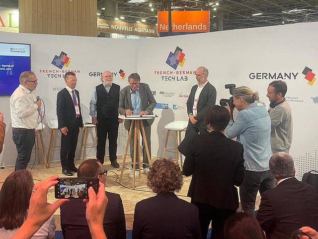 Mehrere Personen stehen an einem Messestand