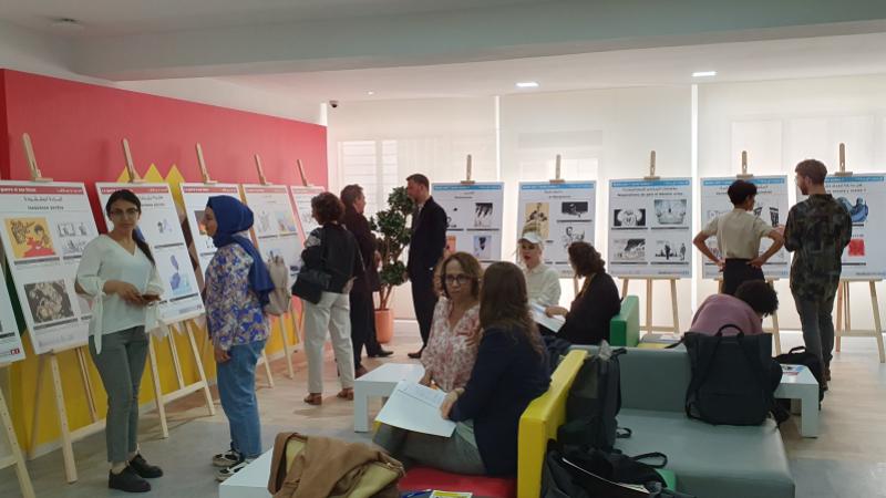 Menschen im Austausch rund um Aufstelltafeln mit Informationen im Rahmen der ersten Konferenz im April 2023 in Tunis