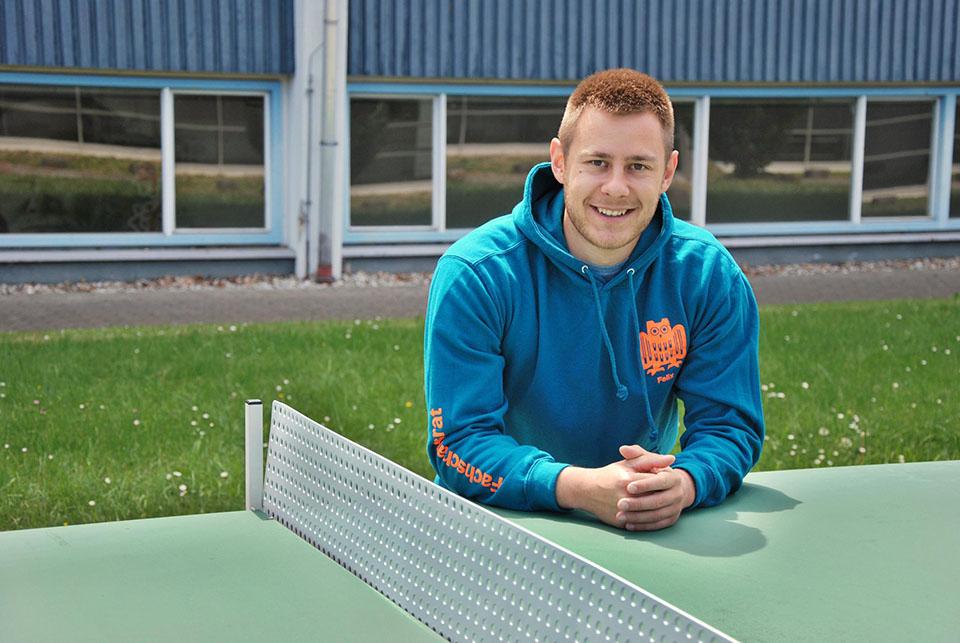 Sportstudent Felix Nimmrichter steht hinter einer Tischtennisplatte