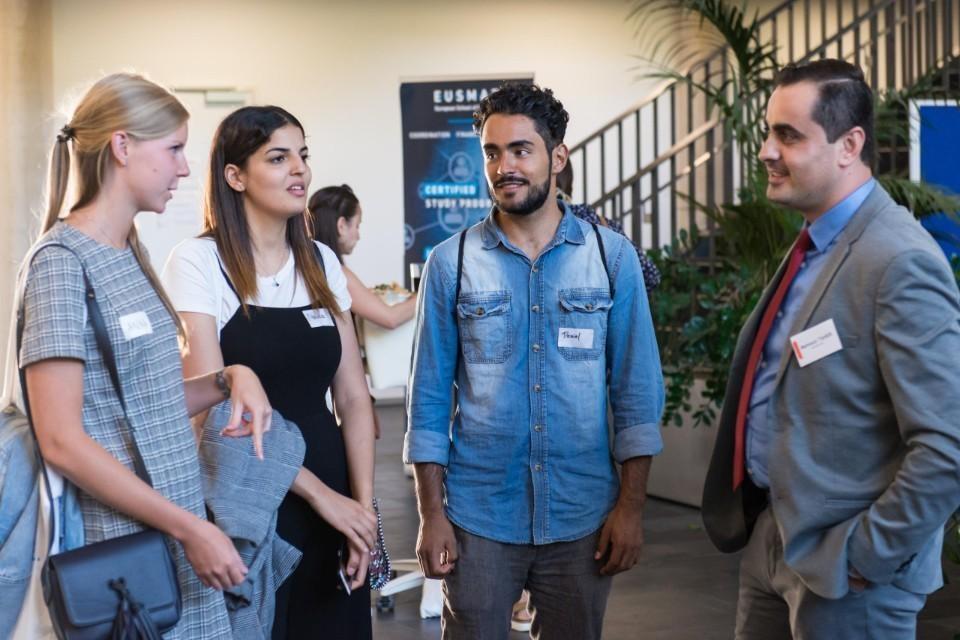 Anna Vikhareva und Daniel Munoz im Gespräch mit einem Industrievertreter beim Programmpunkt "Meet the expert".