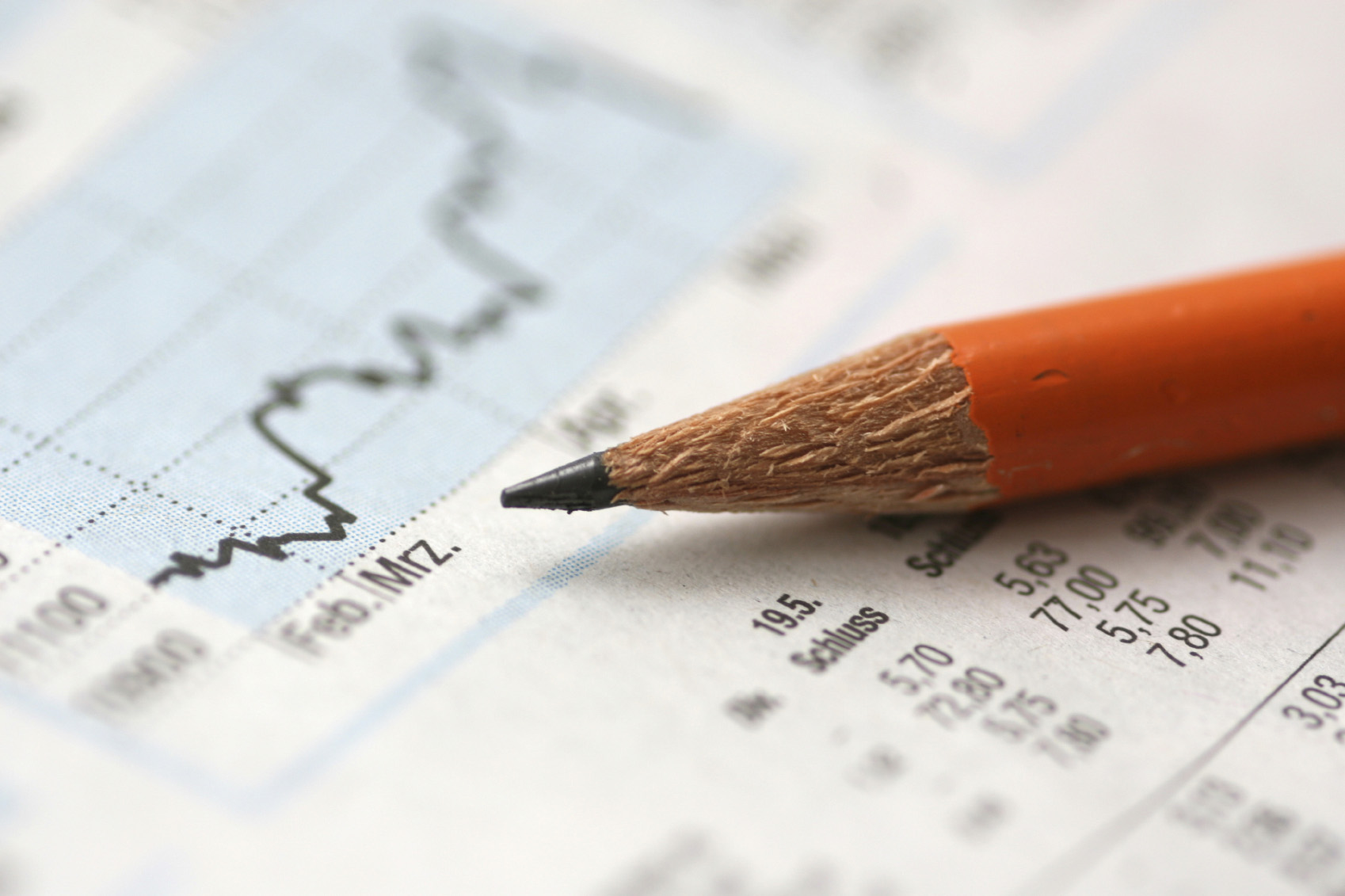 Ein auf finanztechnisch anmutenden Dokumenten liegender Bleistift