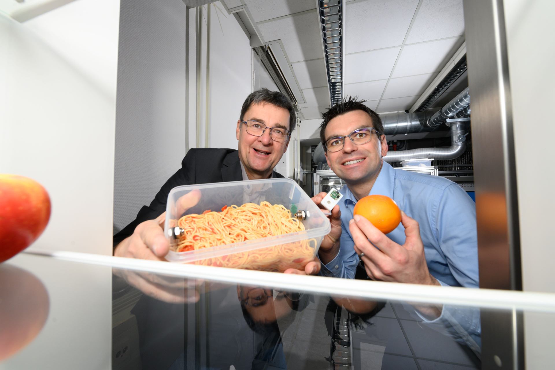 Zwei Wissenschaftler präsentieren Lebensmittel und Sensoren