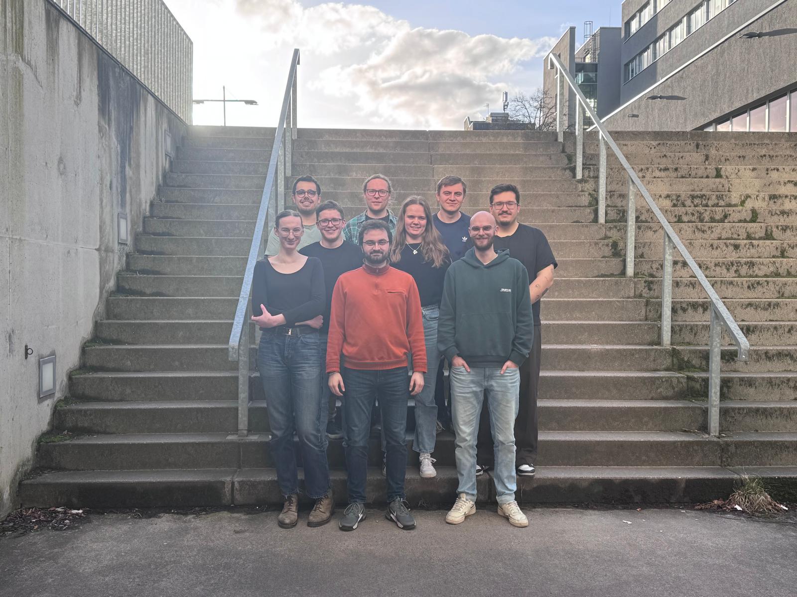Ein Gruppenbild des FSR Chemie. Die Mitglieder stehen alternierend auf einer Treppe.
