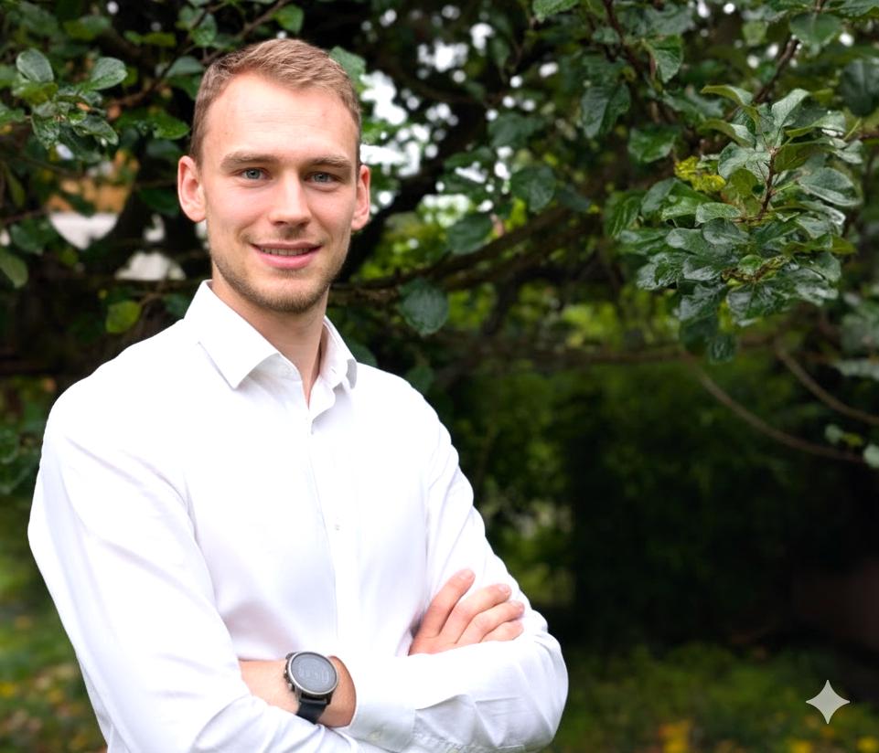 Ein Mann steht vor einem grünen Strauch