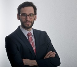ein Mann steht vor einer grauen Wand