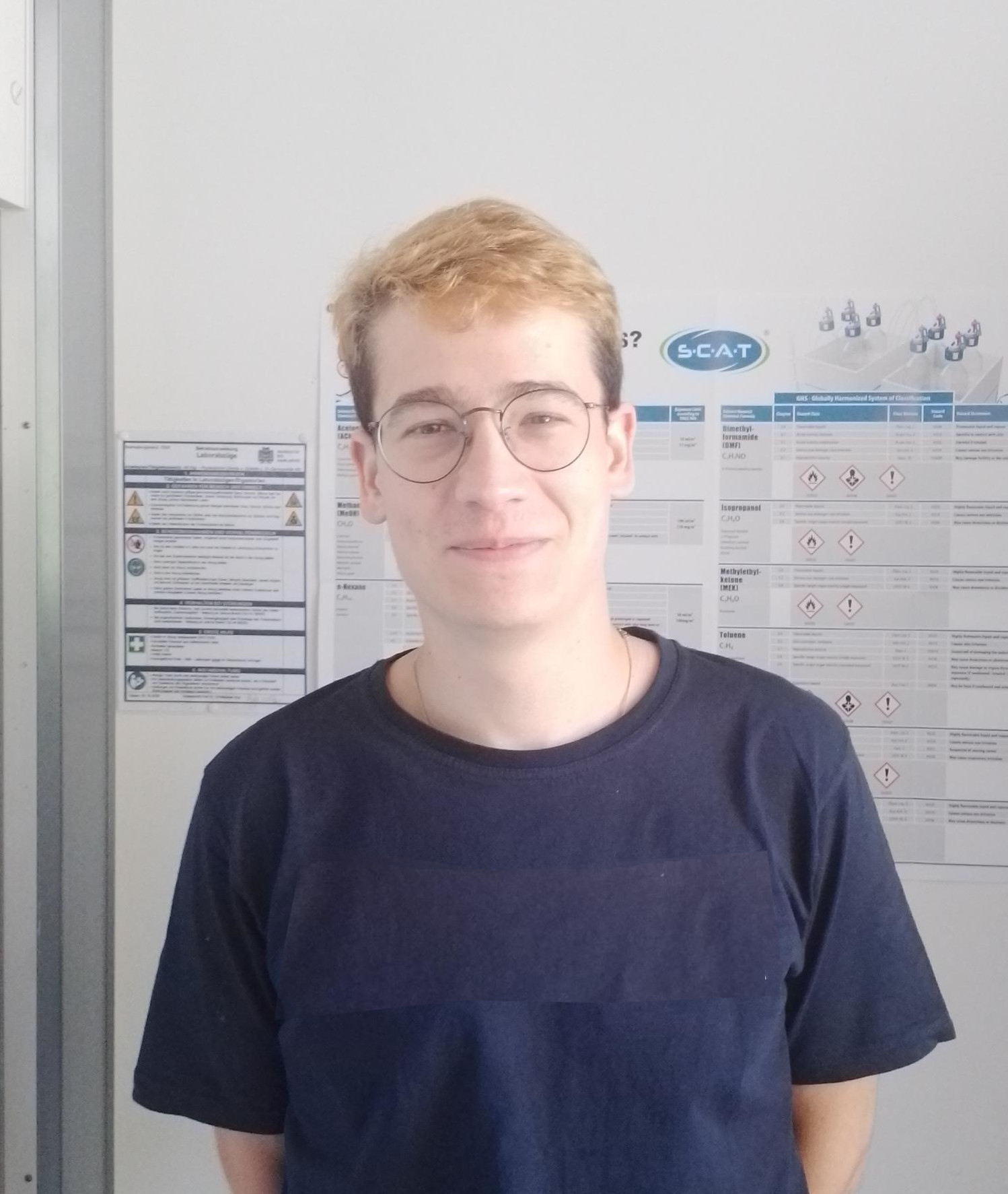 Porträtaufnahme von Janos Brumen vor einer Wand im Labor