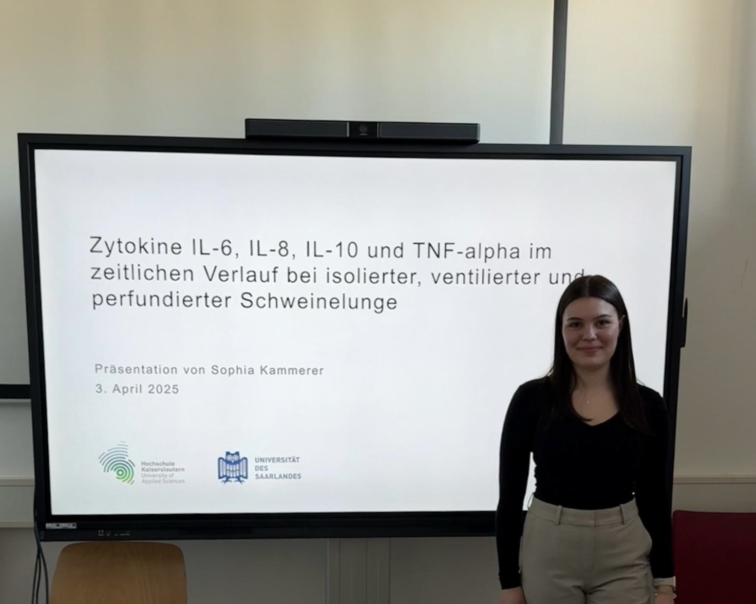 Frau vor Präsentationsbildschirm.