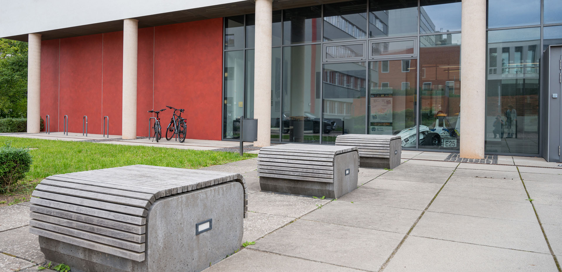 Sitzbänke vor einem Gebäude mit großer Glasfassade