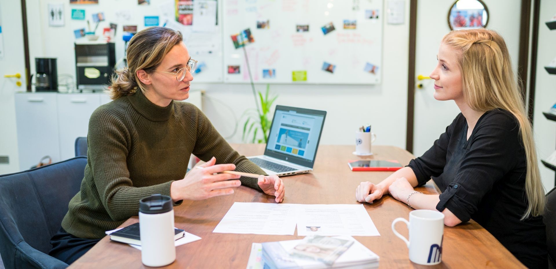 Zwei Frauen sitzen sich beratend ein einem Büro gegenüber 