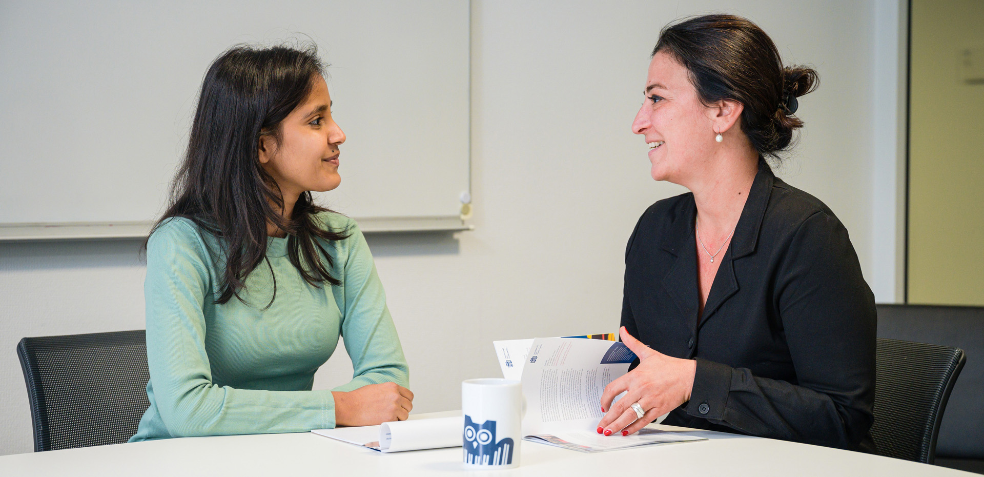 Zwei Frauen an einem Tisch im Gespräch