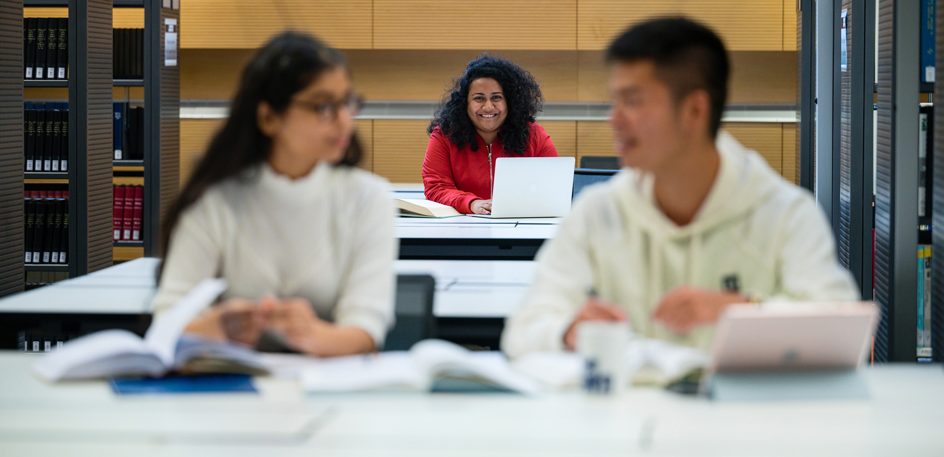 Studierende lernen an Tischen in der Bibliothek