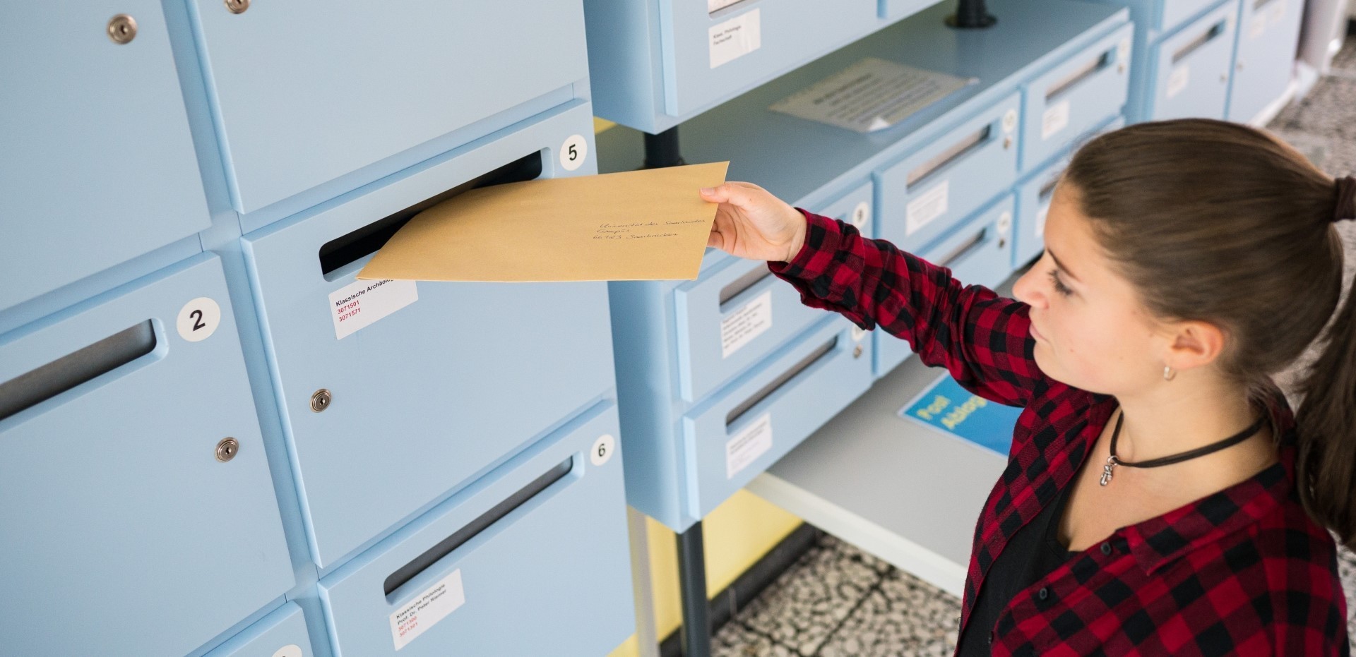 Ein an die Universität des Saarlandes adressierter Brief wird in einen Briefkasten geworfen