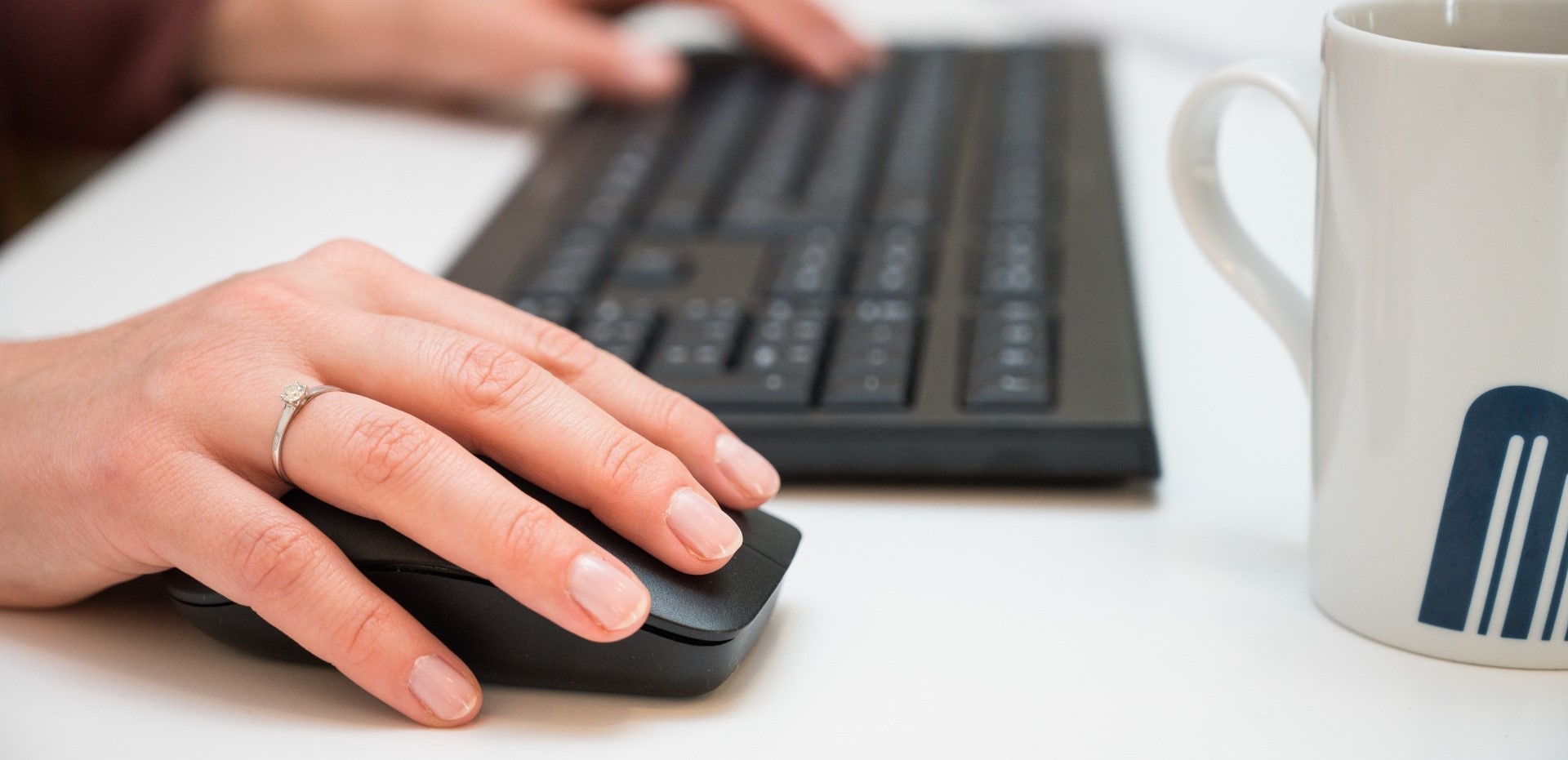 Hände, die eine Tastatur und eine Maus bedienen