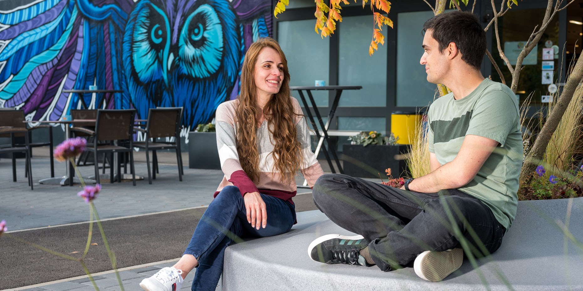 Studierende sitzen vor dem Campus Markt