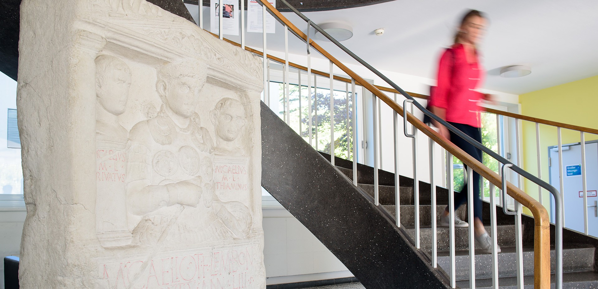 Studentin schreitet schnell eine Treppe herab