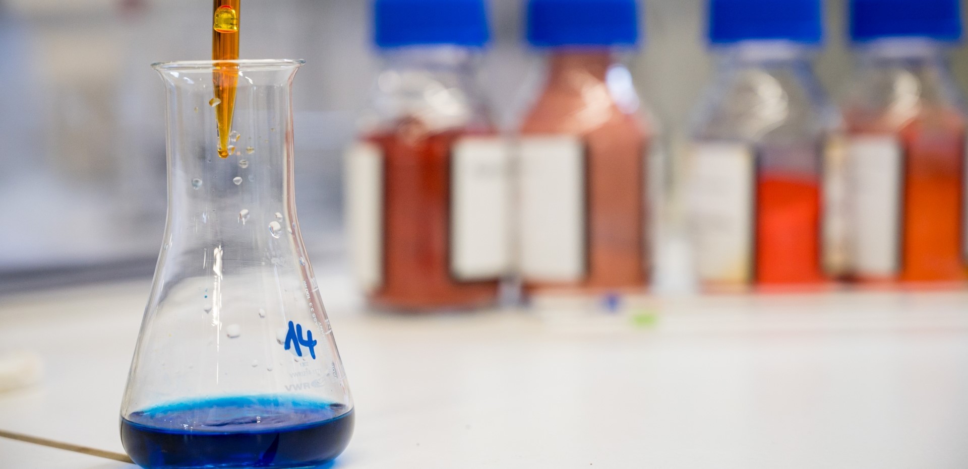 Laborsituation: Glasbehälter mit blauer Flüssigkeit und Pipette