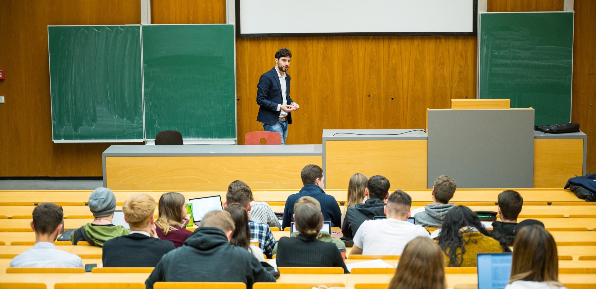 Dozent steht vor Studierenden in einem Hörsaal der Universität des Saarlandes