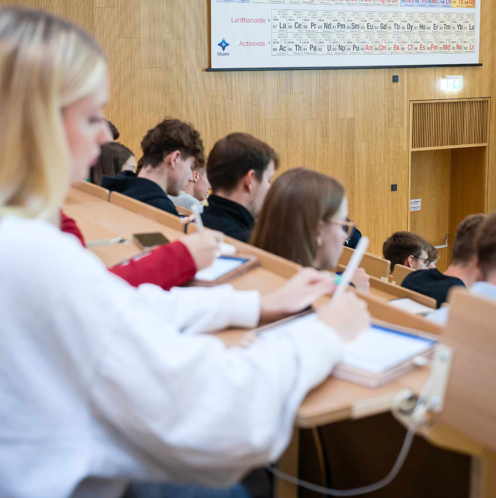 Studentin im Hörsaal macht sich Notizen