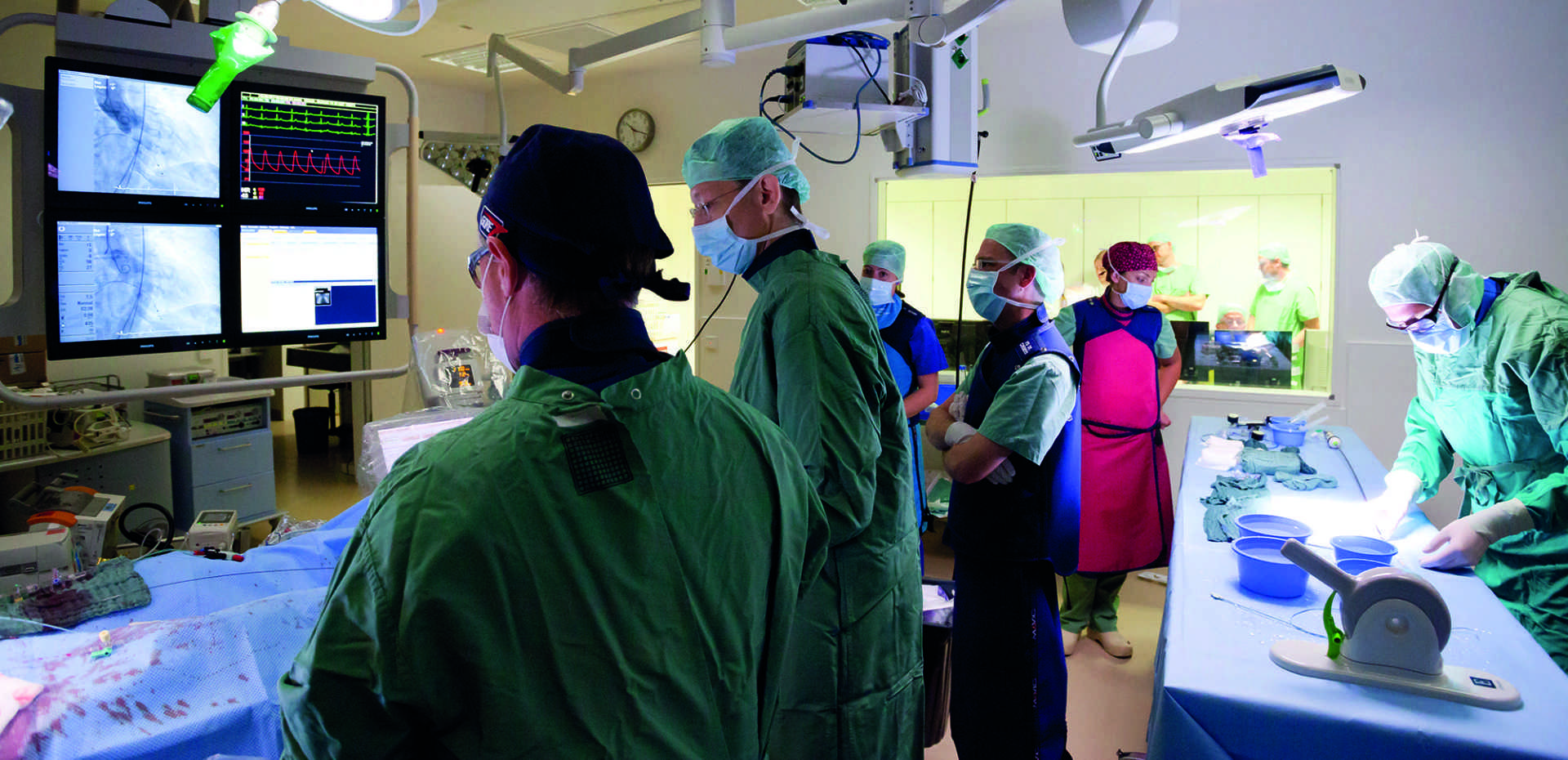 Viele Menschen stehen in einem Operationssaal und arbeiten