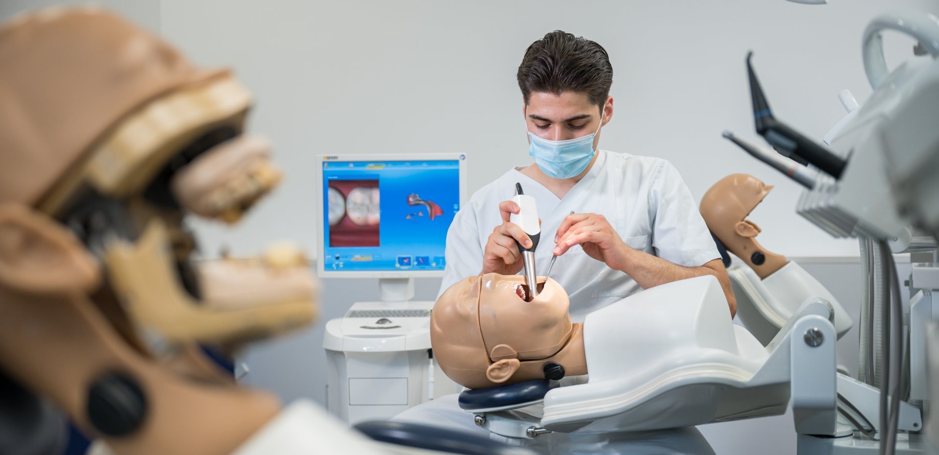 Zahnmedizinstudent übt an einem medizinischem Dummy