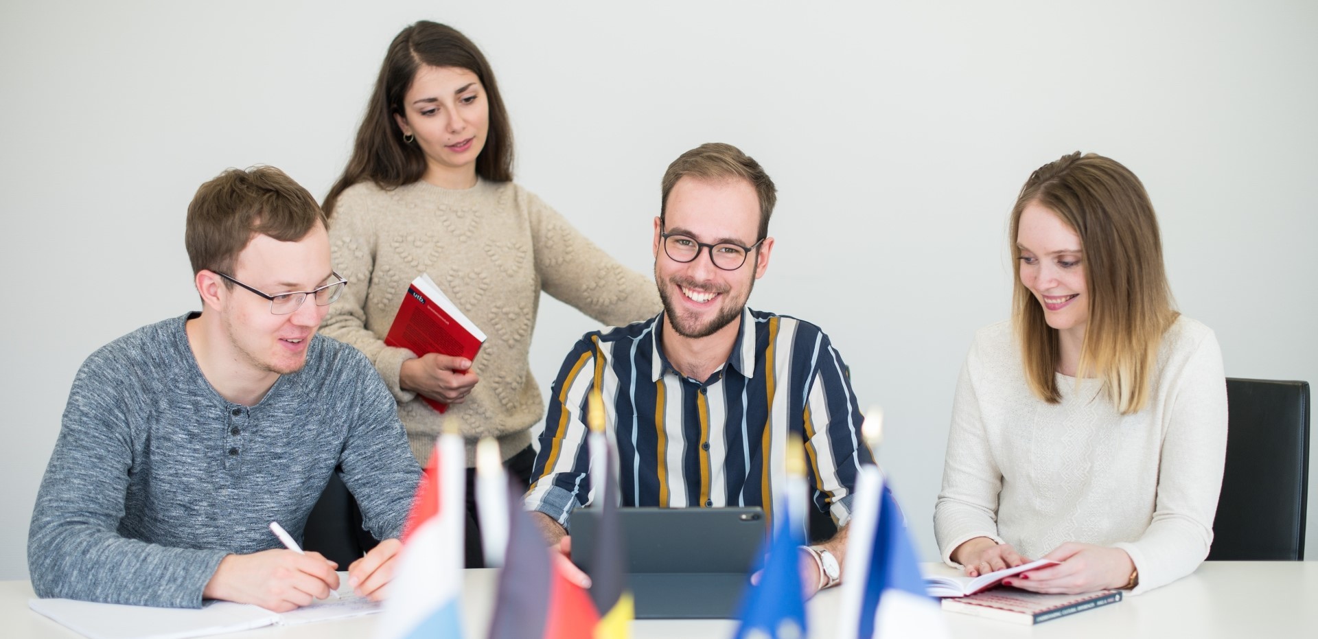 Studierende sitzen in einem Konferenzraum und unterhalten sich