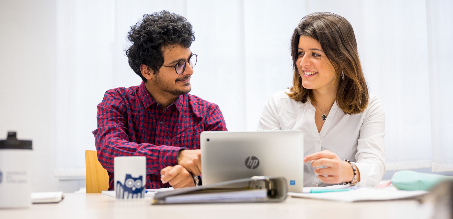 Zwei Studierende sitzen gemeinsam am Schreibtisch