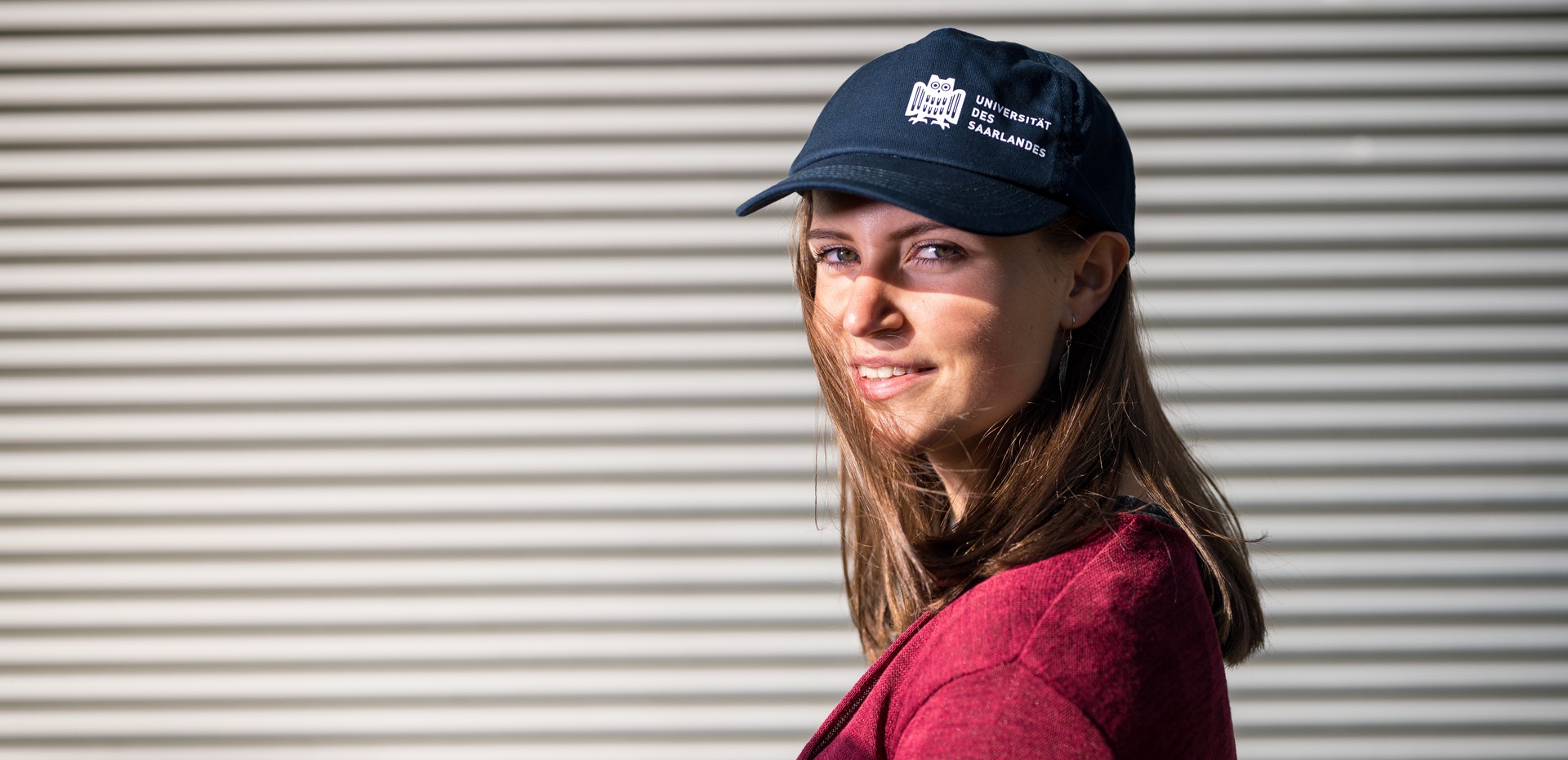 Studentin mit einer Basecap der Universität des Saarlandes